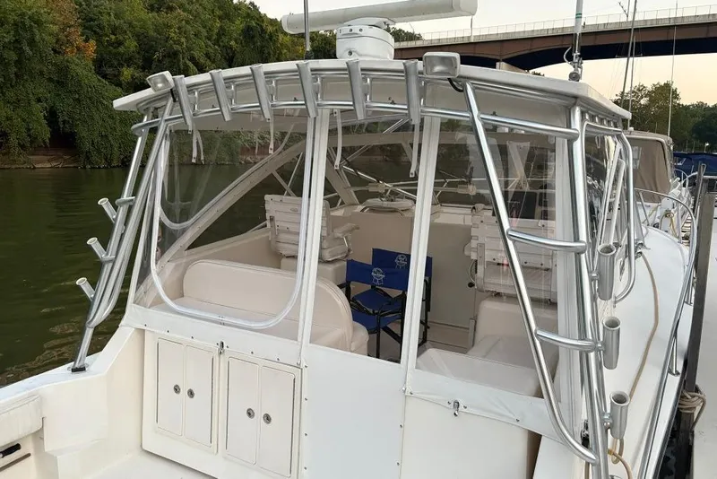 Slide: The Image of 2006 Carolina Classic 32 boat with enclosed cockpit, docked by a river. - 28