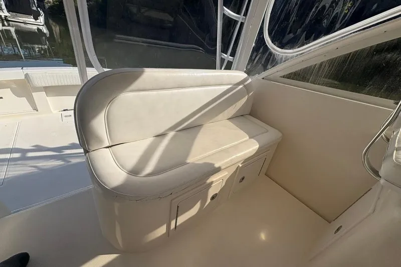 Slide: The Image of Interior seating of a 2006 Carolina Classic 32 boat, featuring white cushioned bench. - 33