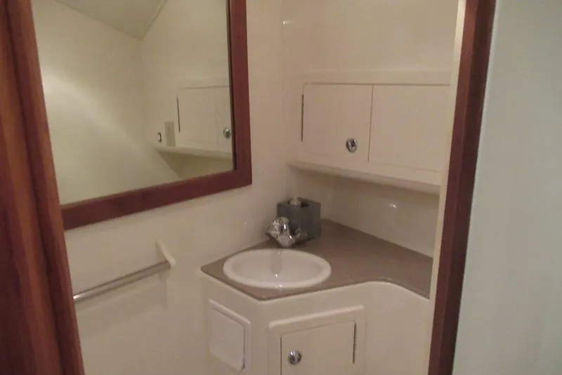 Slide: The Image of 2006 Carolina Classic 32 boat bathroom with sink, mirror, and storage cabinets. - 36