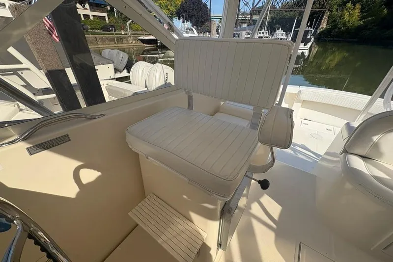 Slide: The Image of Captain's chair on a 2006 Carolina Classic 32 boat, docked near a scenic waterfront. - 42