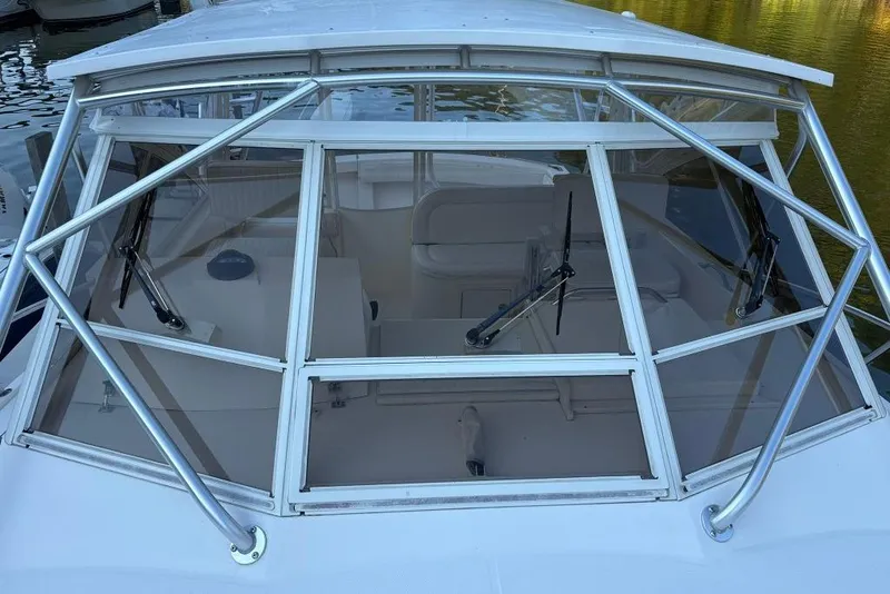 Slide: The Image of 2006 Carolina Classic 32 boat windshield with wipers, docked on calm water. - 5