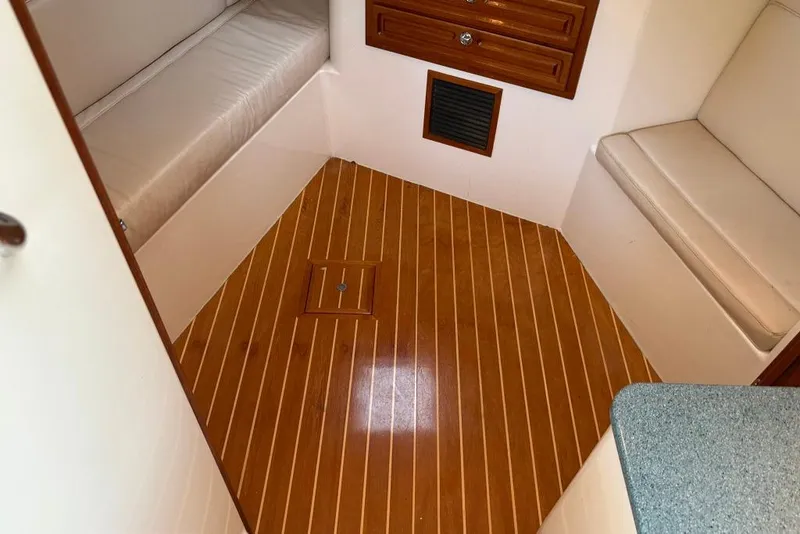 Slide: The Image of 2006 Carolina Classic 32 cabin interior with wood flooring and cushioned seating. - 8