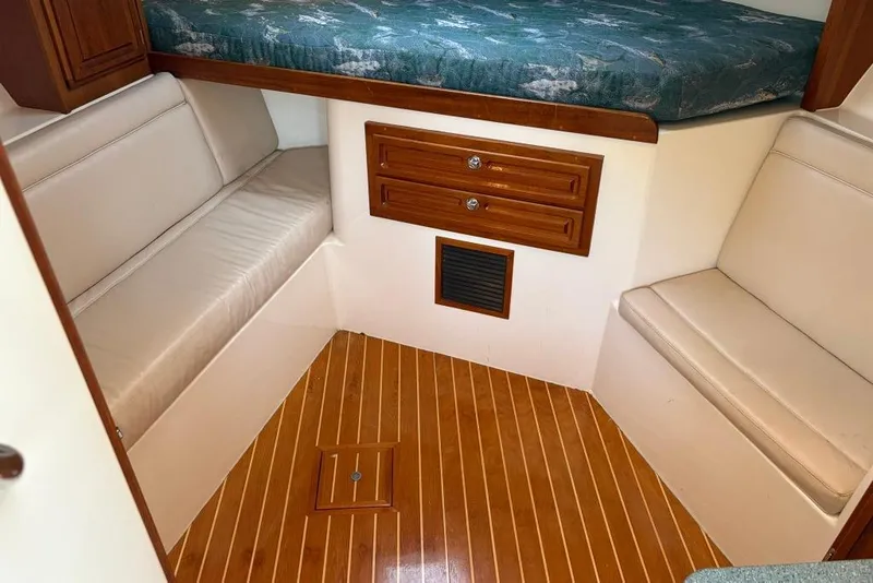 Slide: The Image of 2006 Carolina Classic 32 cabin interior with wood flooring and cushioned seating. - 9