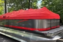 The Image of 2023 Qwest RLS 822 pontoon boat with red cover, parked outdoors. - 0