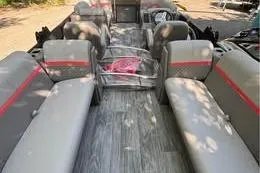 Slide: The Image of 2023 Qwest RLS 822 pontoon boat interior with gray seating and red accents. - 2