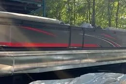 Slide: The Image of 2023 Qwest RLS 822 pontoon boat with sleek red and black design, outdoors. - 3