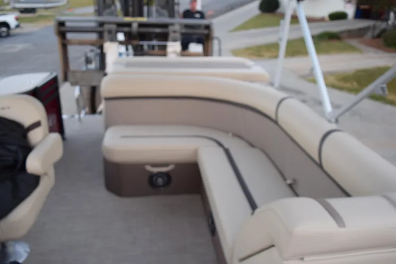 Slide: The Image of 2024 Crest Classic LX 200 L pontoon boat with beige seating and spacious layout. - 11
