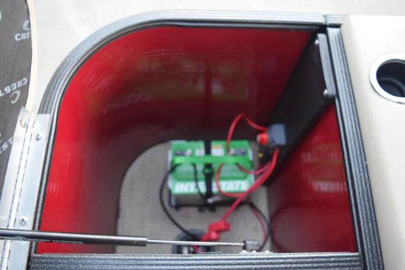 Slide: The Image of Battery compartment of 2024 Crest Classic LX 200 L boat, featuring Interstate battery. - 13