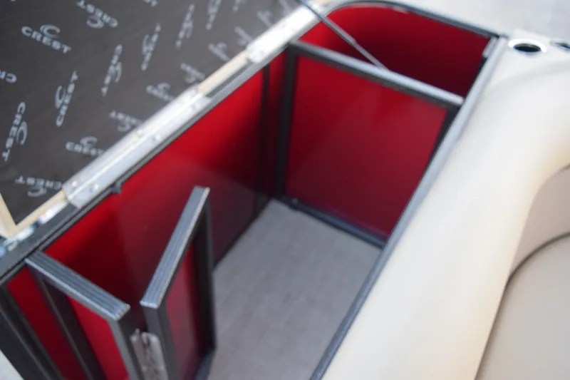 Slide: The Image of 2024 Crest Classic LX 200 L interior storage compartment with red and black design. - 14