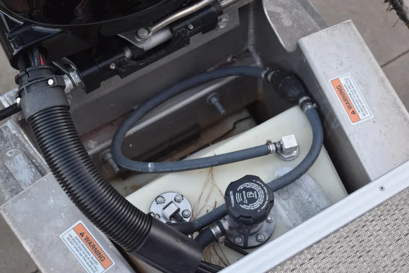 Slide: The Image of 2024 Crest Classic LX 200 L engine compartment with hoses and warning labels. - 15