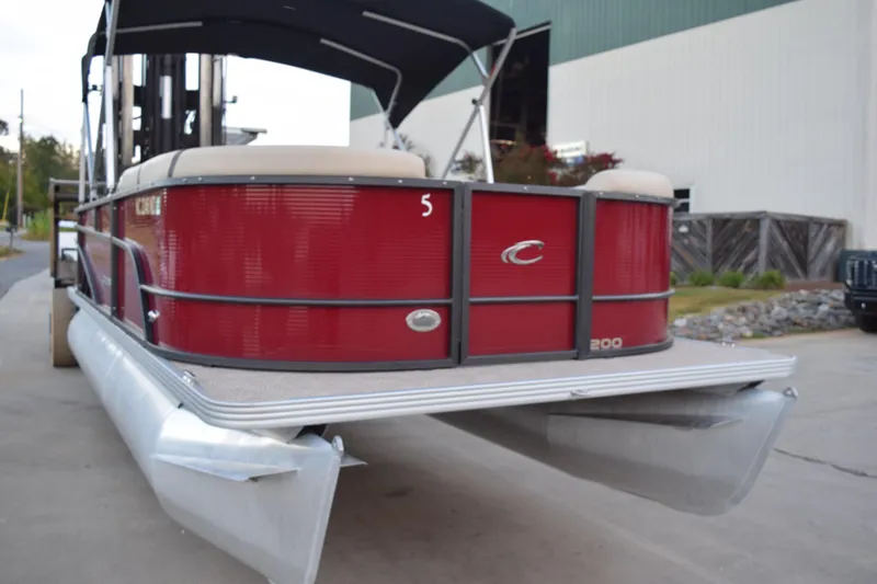 Slide: The Image of 2024 Crest Classic LX 200 L pontoon boat with red exterior and canopy. - 3