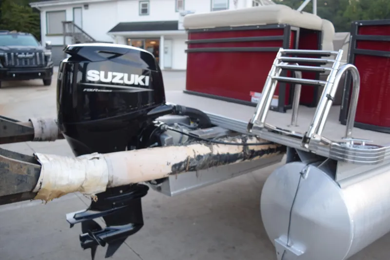 Slide: The Image of 2024 Crest Classic LX 200 L pontoon boat with Suzuki outboard motor, docked on concrete. - 4