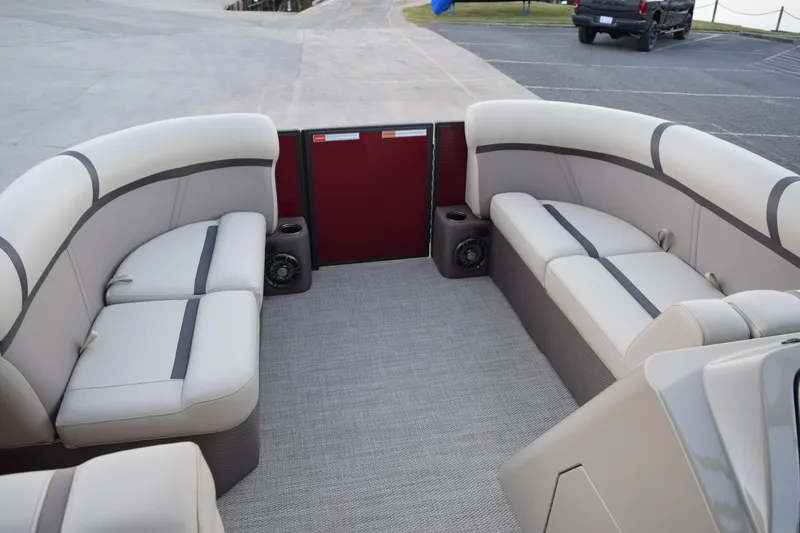 Slide: The Image of 2024 Crest Classic LX 200 L pontoon boat interior with beige seating and speakers. - 7
