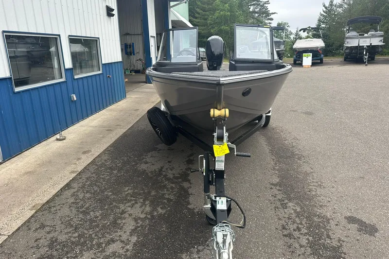 Slide: The Image of 2025 Crestliner 1750 Hawk boat on trailer, parked outside a blue building. - 3