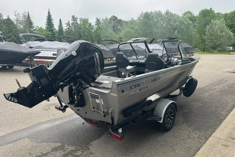 Slide: The Image of 2025 Crestliner 1750 Hawk boat with Mercury engine on trailer, parked outdoors. - 5