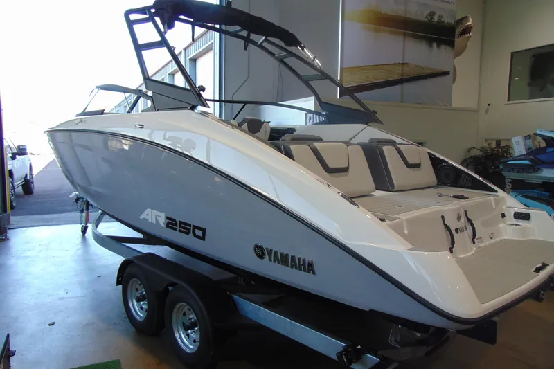 Slide: The Image of 2026 Yamaha Boats AR250 in showroom, sleek design on trailer. - 13