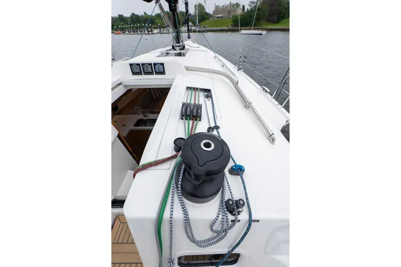 Slide: The Image of 2026 J Boats J/40 sailboat deck with winch and ropes, docked near lush greenery. - 12