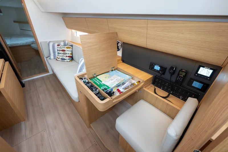 Slide: The Image of 2026 J Boats J/40 interior with navigation station, wooden cabinetry, and cozy seating area. - 33