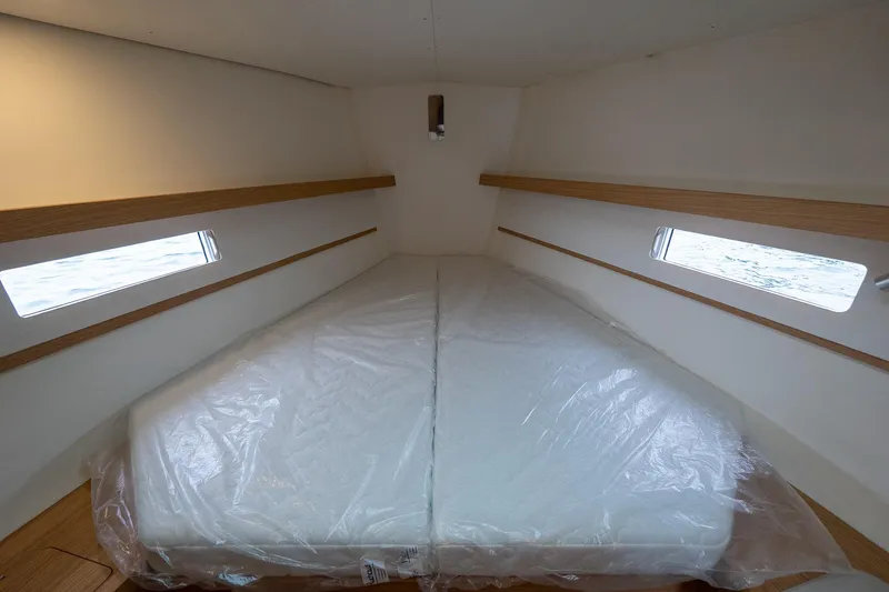 Slide: The Image of Interior cabin of 2026 J Boats J/40 with twin windows and a wrapped mattress. - 46