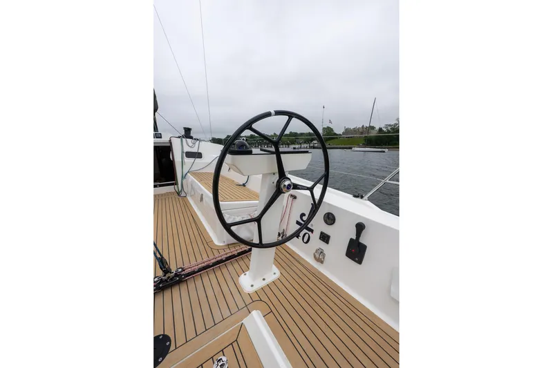 Slide: The Image of 2026 J Boats J/40 sailboat cockpit with steering wheel, docked by a scenic waterfront. - 9