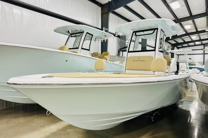 The Image of 2026 Sportsman Masters 247 Bay Boat in showroom, featuring sleek design and modern amenities. - 2