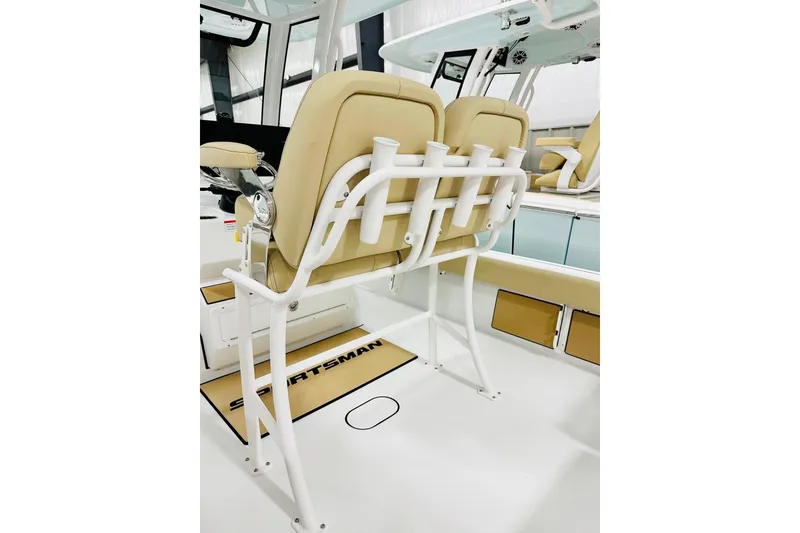 Slide: The Image of 2026 Sportsman Masters 247 Bay Boat interior with beige seating and rod holders. - 6