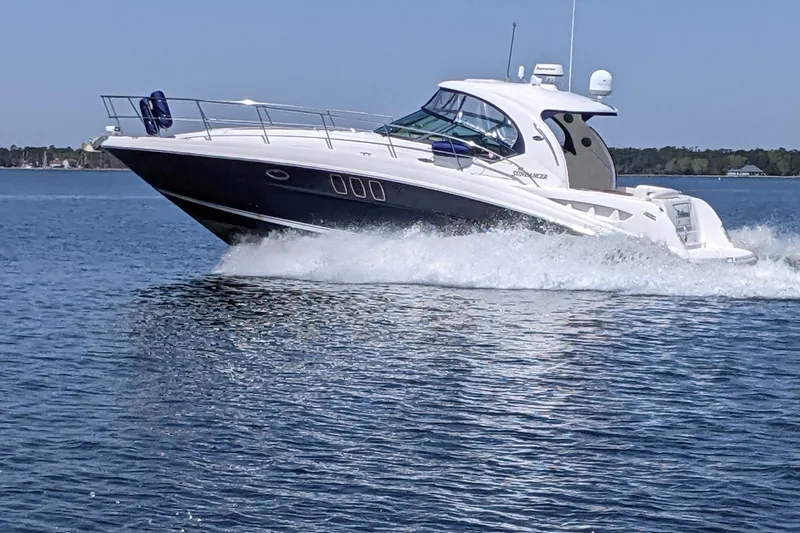 The Image of 2007 Sea Ray 40 Sundancer cruising on open water, creating a dynamic wake. - 1
