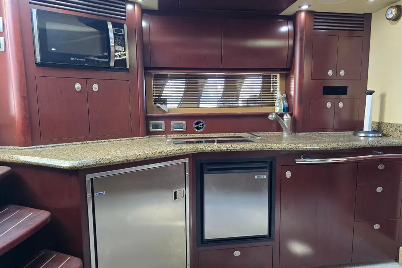 Slide: The Image of 2007 Sea Ray 40 Sundancer yacht kitchen with wood cabinetry and modern appliances. - 13