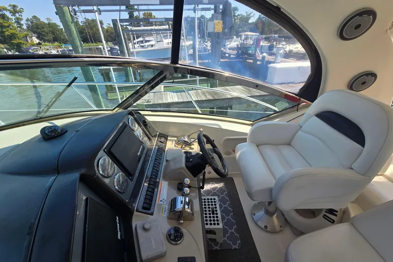 Slide: The Image of Helm of 2007 Sea Ray 40 Sundancer with white captain's chair and control panel. - 36