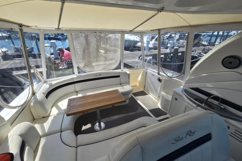 Slide: The Image of 2007 Sea Ray 40 Sundancer interior with white seating and wooden table at marina. - 37