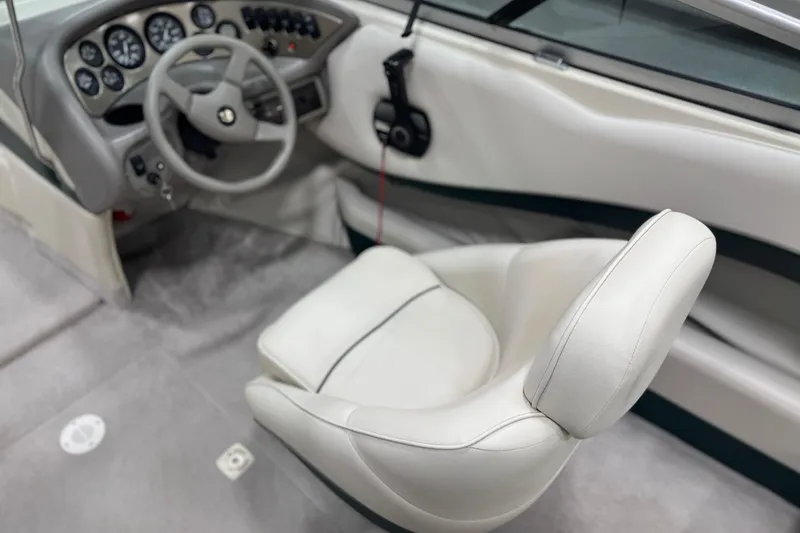 Slide: The Image of Interior of a 1998 Crownline 202 BR boat with steering wheel and white seating. - 12