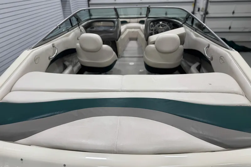 Slide: The Image of 1998 Crownline 202 BR boat interior with white and teal seating, showcasing steering wheel and dashboard. - 6