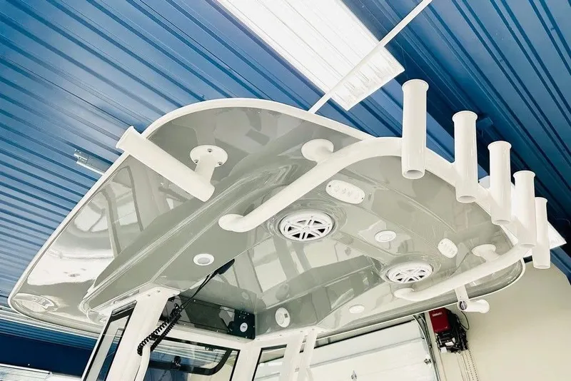 Slide: The Image of 2026 Sportsman Open 232 Center Console boat's T-top with rod holders and speakers. - 3