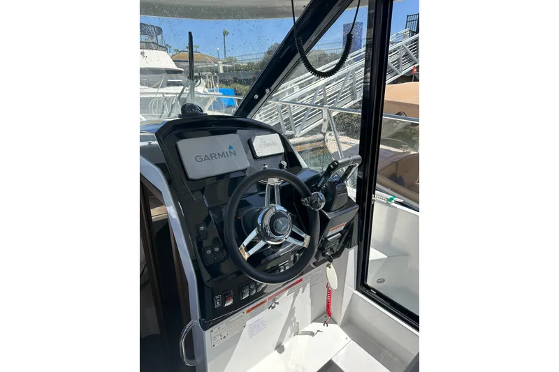Slide: The Image of 2021 Jeanneau NC895 helm with Garmin navigation system and steering wheel. - 12