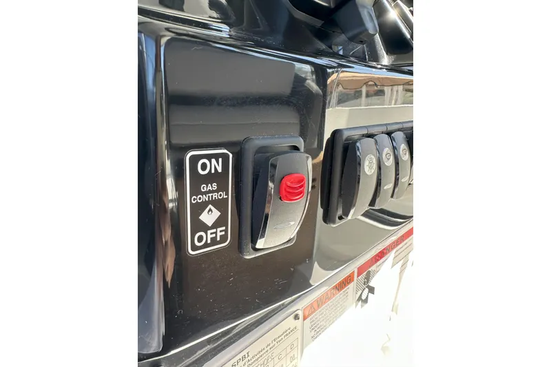 Slide: The Image of Gas control panel on a 2021 Jeanneau NC895 boat, featuring on/off switch and warning labels. - 20