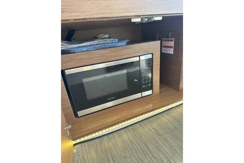Slide: The Image of Microwave in 2021 Jeanneau NC895 boat interior, wooden cabinetry, modern design. - 25