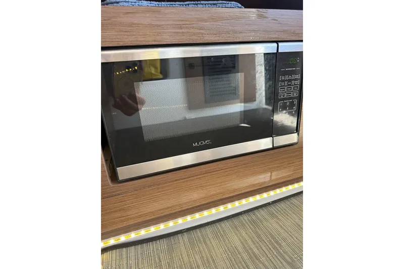 Slide: The Image of Microwave oven in 2021 Jeanneau NC895 boat interior, wood paneling. - 26