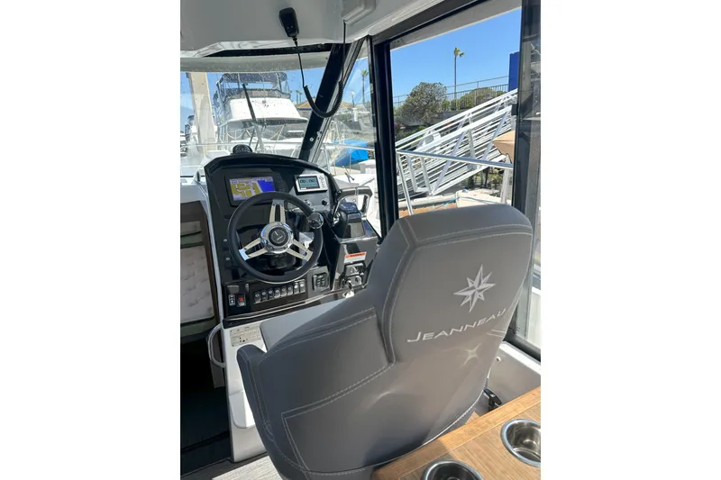 Slide: The Image of 2021 Jeanneau NC895 helm with steering wheel, navigation display, and branded seat. - 3