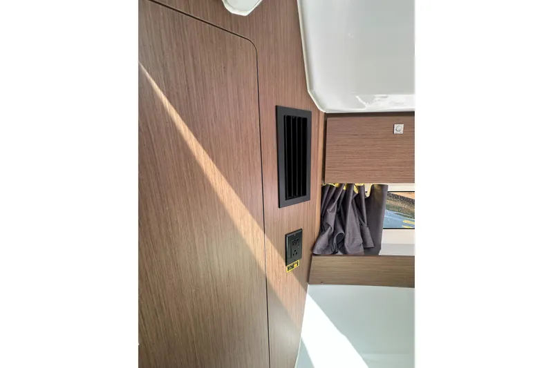Slide: The Image of Interior of 2021 Jeanneau NC895 boat with wood paneling and window curtain. - 32