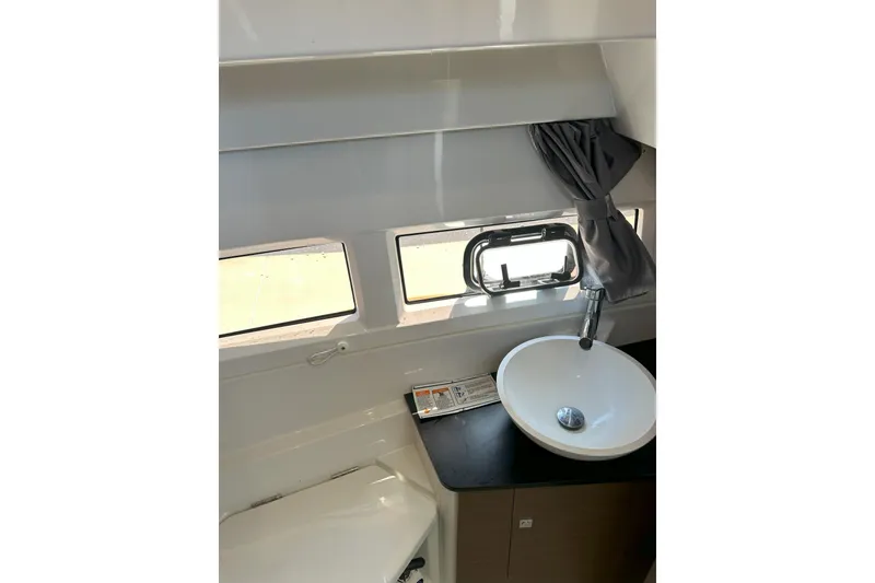 Slide: The Image of 2021 Jeanneau NC895 bathroom interior with sink, window, and curtain. - 36