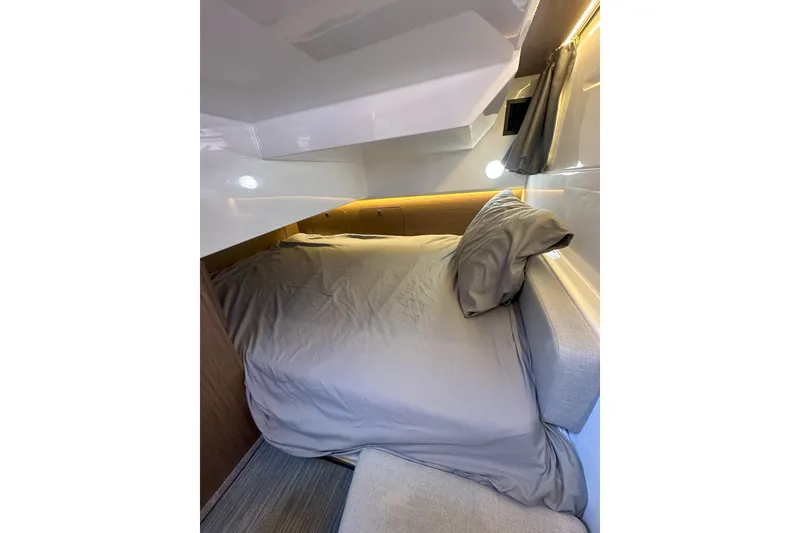 Slide: The Image of Cozy cabin interior of 2021 Jeanneau NC895 with comfortable bedding and ambient lighting. - 38