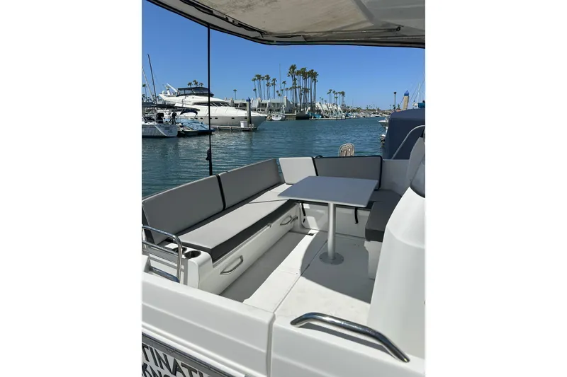 Slide: The Image of 2021 Jeanneau NC895 boat with seating area and table, docked in a marina. - 5