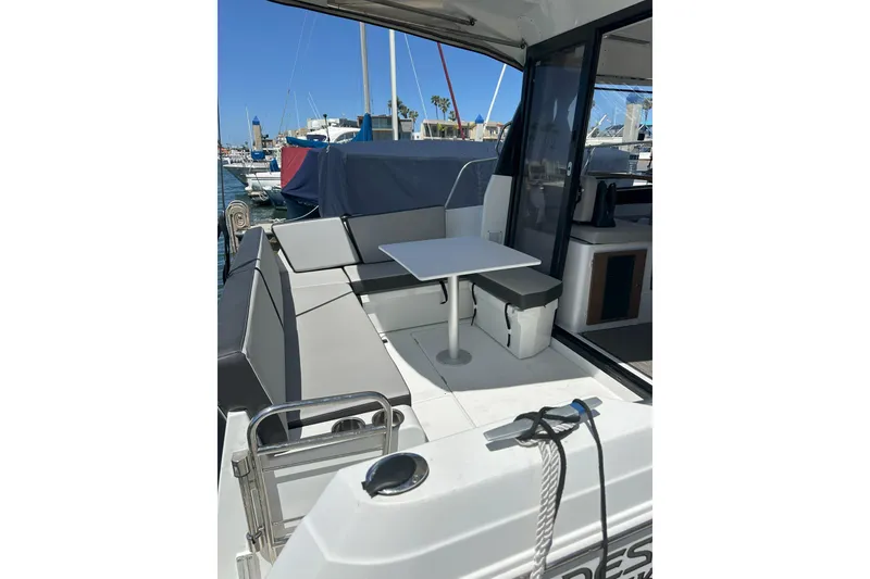 Slide: The Image of 2021 Jeanneau NC895 boat with outdoor seating and table in a marina setting. - 7