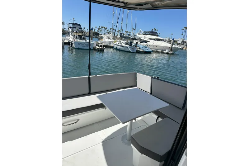 Slide: The Image of 2021 Jeanneau NC895 boat interior with seating and table, docked at marina. - 8