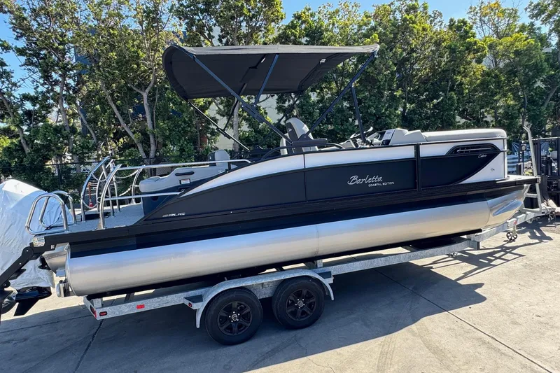 Slide: The Image of 2026 Barletta Cabrio 22UC pontoon boat on trailer, parked outdoors. - 10