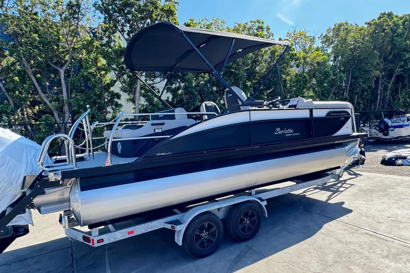 Slide: The Image of 2026 Barletta Cabrio 22UC pontoon boat on trailer, parked outdoors. - 11
