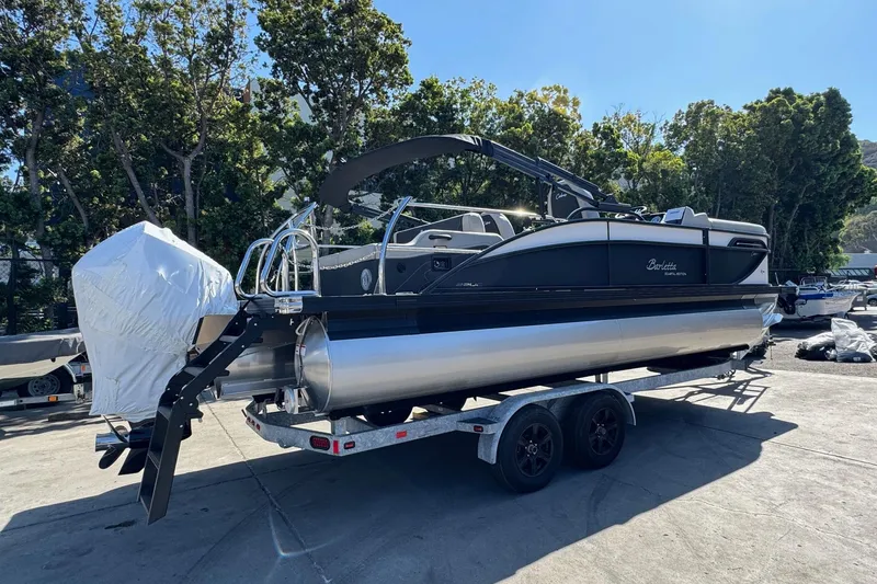 Slide: The Image of 2026 Barletta Cabrio 22UC pontoon boat on trailer, parked outdoors. - 23