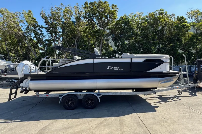 Slide: The Image of 2026 Barletta Cabrio 22UC pontoon boat on trailer, parked outdoors. - 25