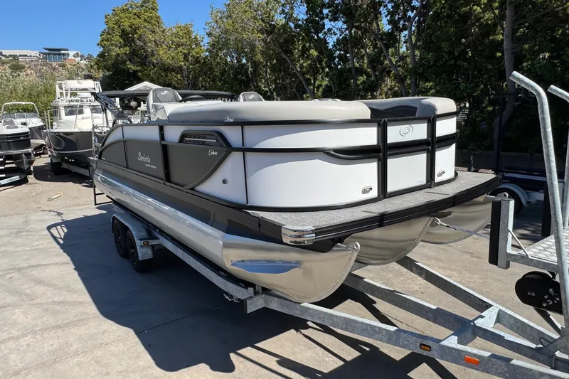 Slide: The Image of 2026 Barletta Cabrio 22UC pontoon boat on trailer, parked outdoors. - 28