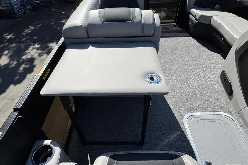 Slide: The Image of 2026 Barletta Cabrio 22UC boat interior with gray seating and table, featuring cup holders. - 48